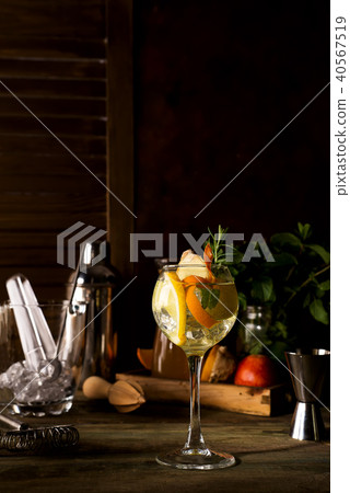 Cocktail with rosemary, lemon and orange on dark wooden backgorund Cocktail with rosemary, lemon and orange on dark wooden backgorund 40567519