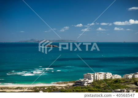 small stony islands in the azure sea with beach and houses foreground 40568547