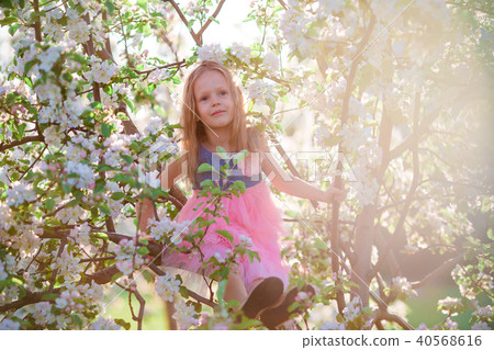Adorable little girl enjoying spring day in apple blooming garden 40568616