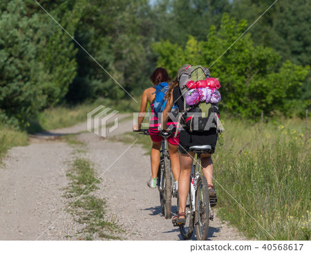 Pretty girl cycling in the wild nature on dirt road. Bikes cycling girl. Girl rides bicycle. Pretty girl cycling in the wild nature on dirt road. Bikes cycling girl. Girl rides bicycle. 40568617