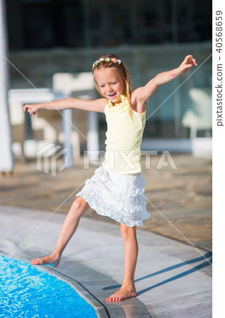 Little girl having fun with a splash near swimming pool Little girl having fun with a splash near swimming pool 40568659