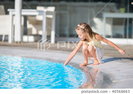 Little girl having fun with a splash near swimming pool 40568663