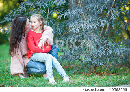 Adorable little girl with young mother in blooming garden on spring day Adorable little girl with young mother in blooming garden on spring day 40568966