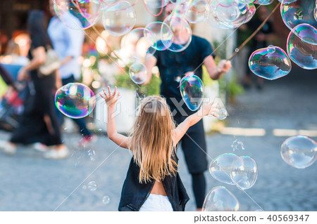 Adorable little girl blowing soap bubbles in Trastevere in Rome, Italy 40569347