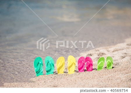 Family colorful flip flops on beach in front of the sea Family colorful flip flops on beach in front of the sea 40569754