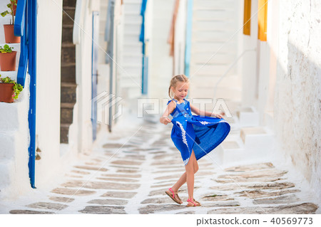 Girl in blue dresses having fun outdoors on Mykonos streets Girl in blue dresses having fun outdoors on Mykonos streets 40569773