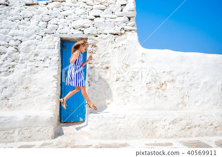 Girl in blue dresses having fun outdoors on Mykonos streets Girl in blue dresses having fun outdoors on Mykonos streets 40569911