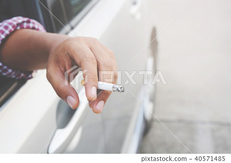 close up hand smoking a cigarette in car. close up hand smoking a cigarette in car. 40571485