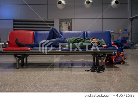 young tourist man is sleeping in a airport  40571582