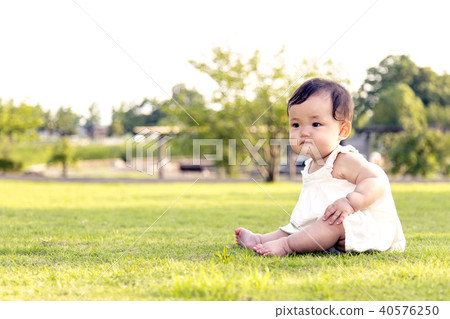 單獨坐在公園草坪和使用的女嬰 40576250