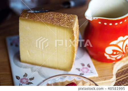 Spicy hard cheese and red old pitcher. 40581995