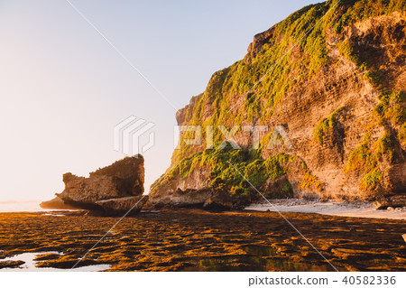 High cliff with rocks, stones, low tide ocean High cliff with rocks, stones, low tide ocean 40582336