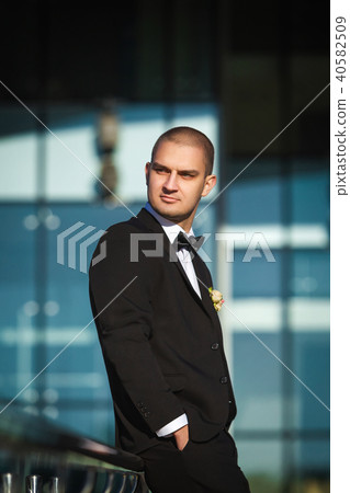 stylish groom sitting on modern handrails 40582509