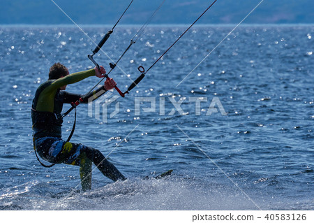 male kiteboarder rides on a board on a large river male kiteboarder rides on a board on a large river 40583126