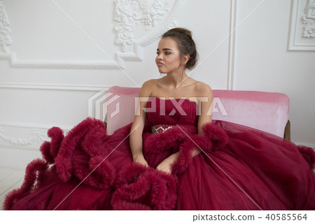 Cheerful young woman in a burgundy ball gown. Cheerful young woman in a burgundy ball gown. 40585564