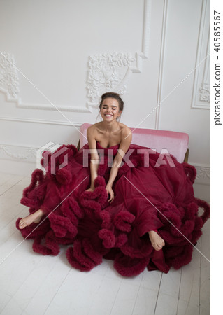 Cheerful young woman in a burgundy ball gown. Cheerful young woman in a burgundy ball gown. 40585567