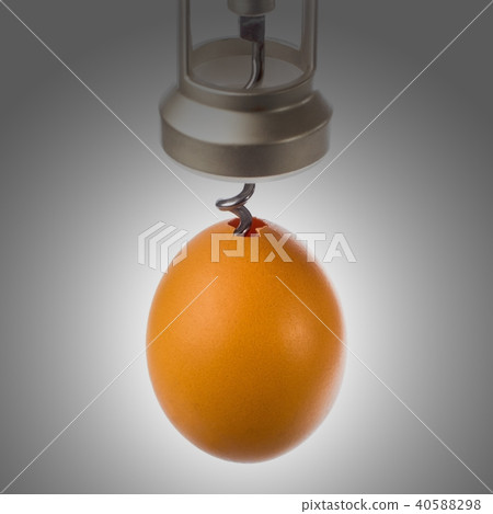 the corkscrew is screwed into the egg close-up 40588298