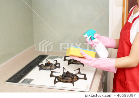 A woman cleaning a kitchen A woman cleaning a kitchen 40589397