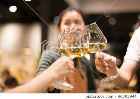 Friends raising a toast with glasses of white wine Friends raising a toast with glasses of white wine 40593944