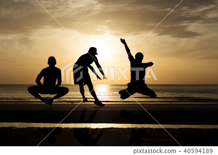 Group of friends jumping on the beach in sunset Group of friends jumping on the beach in sunset 40594189