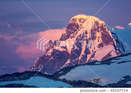 Antarctic mountain on the colorful sky background. Antarctic mountain on the colorful sky background. 40597554