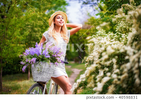 beautiful young girl with vintage bicycle and flowers on city background in the sunlight outdoor. beautiful young girl with vintage bicycle and flowers on city background in the sunlight outdoor. 40598831