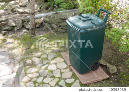 Green plastic garbge bin in garden.Single garbage container stand in park 40598989
