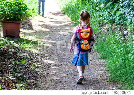 Little girls walking away with her filled backpack Little girls walking away with her filled backpack 40610685