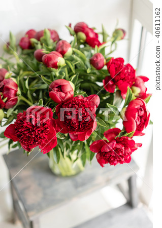 Lovely flowers in glass vase. Beautiful bouquet of red peonies . Floral composition, scene, daylight 40611162