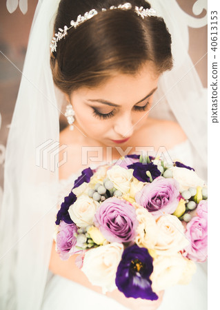 Luxury bride in white dress posing while preparing for the wedding ceremony 40613153