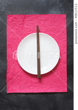 Asian style. White plate with chopsticks on red. Asian style. White plate with chopsticks on red. 40613513