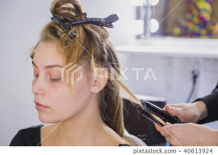 Hairstylist straightening the long brown hair 40613924