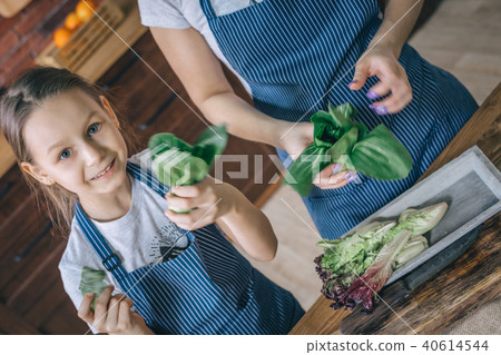 Cheerful girl cooking vegetables with mother Cheerful girl cooking vegetables with mother 40614544