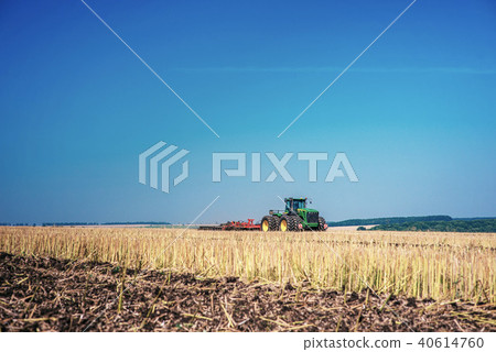 Tractor plowing farm field in preparation for spring planting. 40614760