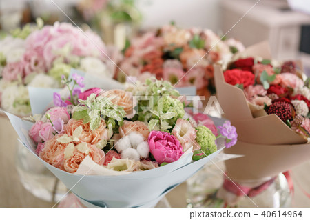 Floristry concept. Four bouquet of beautiful flowers on gray table. Spring colors. the work of the Floristry concept. Four bouquet of beautiful flowers on gray table. Spring colors. the work of the 40614964
