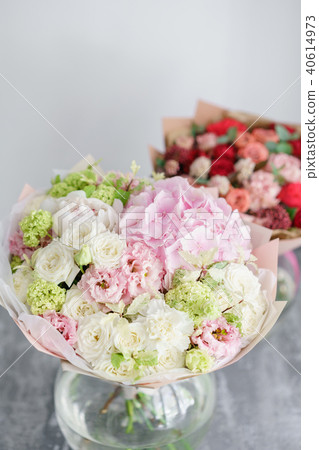 Floristry concept. Two bouquet of beautiful flowers on gray table. Spring colors. the work of the Floristry concept. Two bouquet of beautiful flowers on gray table. Spring colors. the work of the 40614973