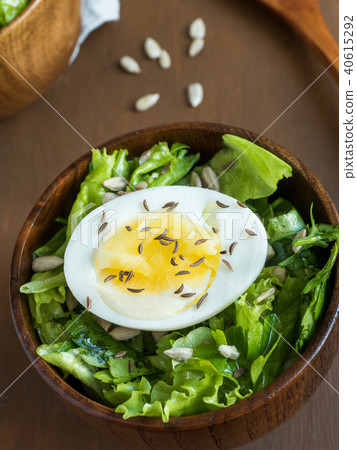 Salad of lettuce leaves and eggs in wooden bowls Salad of lettuce leaves and eggs in wooden bowls 40615292