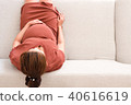 Young pregnant woman sitting on gray sofa top view 40616619