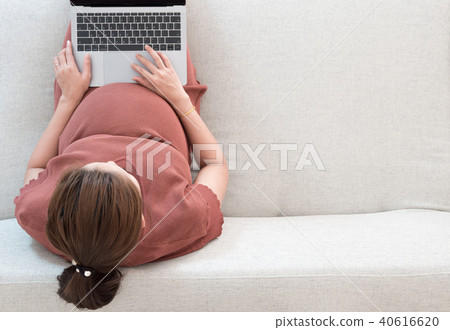 Pregnant woman searching news and online shopping 40616620