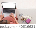 Pregnant woman is shopping online with laptop. 40616621