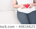 Happy pregnant woman holding love red heart shape. 40616625