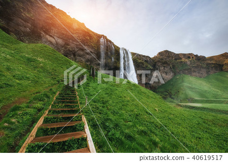 Seljalandfoss waterfall at sunset. Bridge over the river. Fantas 40619517