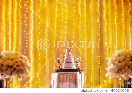 Beautiful wedding cake on stage with yellow light Beautiful wedding cake on stage with yellow light 40621606