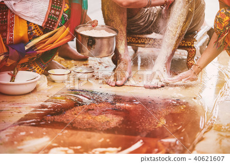 Women pasting turmeric powder on groom feet Women pasting turmeric powder on groom feet 40621607
