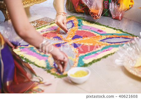 Bride's friend helps coloring rice art (Rangoli) 40621608