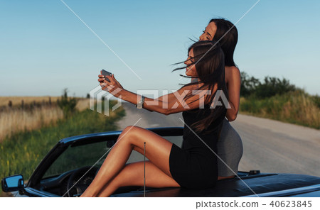 Beautiful two girls are photographed on the road Beautiful two girls are photographed on the road 40623845