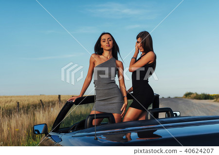 Beautiful two women sitting in a convertible Beautiful two women sitting in a convertible 40624207