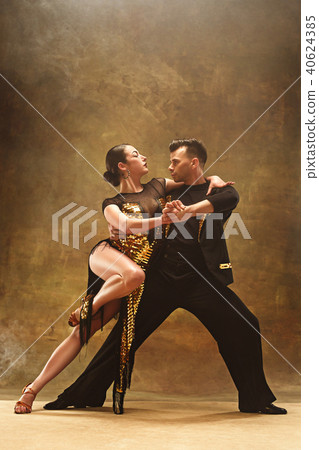 Dance ballroom couple in gold dress dancing on studio background. Dance ballroom couple in gold dress dancing on studio background. 40624385