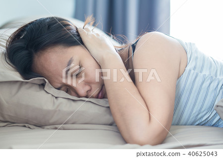 woman lying in bed suffering from sound covering woman lying in bed suffering from sound covering 40625043