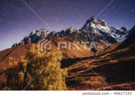 Fantastic starry sky. Autumn landscape and snow-capped peaks 40627183